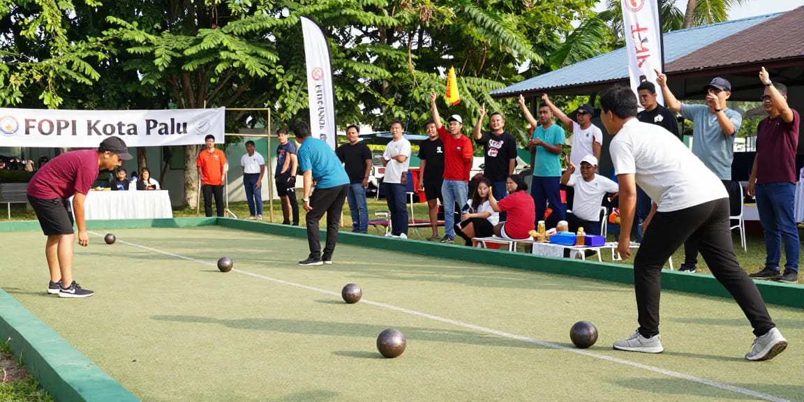 Pertandingan petanque di fopikotapalu.org dengan pemain bersemangat dan penonton yang mendukung.